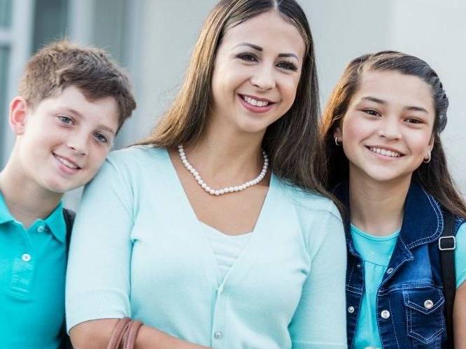 Woman and younger children smiling for a picture